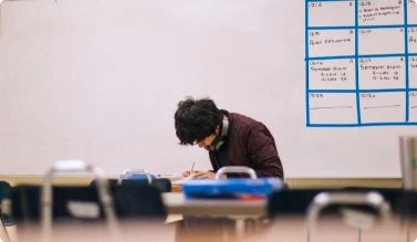 Student working at a desk in an AMCC Peace Academy classroom